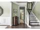 Hallway with staircase, olive walls, and traditional decor leading to multiple rooms at 1850 Overlook Springs Ln, Cumming, GA 30040