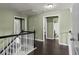 Upstairs hallway with neutral paint, wood flooring, and multiple doorways leading to other rooms at 1850 Overlook Springs Ln, Cumming, GA 30040