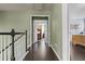 Bright hallway with dark hardwood floors leads to bedrooms with a stairway visible on the left at 1850 Overlook Springs Ln, Cumming, GA 30040