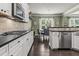 Bright eat-in kitchen features white cabinets, stainless appliances and black countertops at 1850 Overlook Springs Ln, Cumming, GA 30040