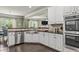 Bright eat-in kitchen features white cabinets, stainless appliances and a large apron sink at 1850 Overlook Springs Ln, Cumming, GA 30040