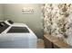 A laundry room with a washing machine, dryer, decorative wallpaper, and a sign on the wall at 1850 Overlook Springs Ln, Cumming, GA 30040