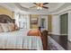 Spacious main bedroom with a tray ceiling, a ceiling fan and dark wood flooring at 1850 Overlook Springs Ln, Cumming, GA 30040