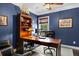Blue office space with a built-in bookshelf and large desk at 1850 Overlook Springs Ln, Cumming, GA 30040