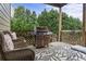 Back patio with outdoor seating, a grill and views of mature trees at 1850 Overlook Springs Ln, Cumming, GA 30040