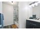 This bathroom features a black vanity, gray plank flooring, and a shower over tub with glass doors at 189 Timber Creek Ln, Marietta, GA 30060