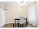 Contemporary dining area with a black table, white chairs, and bright window at 189 Timber Creek Ln, Marietta, GA 30060