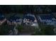 Night aerial view of a neighborhood featuring modern homes, manicured lawns, and well-lit driveways at 2631 Sardis Way, Buford, GA 30519