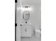 Bright half bathroom with decorative oval mirror, modern lighting, and white fixtures at 2631 Sardis Way, Buford, GA 30519
