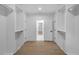 Walk-in closet offers custom shelving, hardwood floors, and open doorway at 2631 Sardis Way, Buford, GA 30519