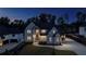 Elegant two-story home with modern architectural details and manicured front yard, showcasing sophisticated curb appeal at night at 2631 Sardis Way, Buford, GA 30519