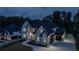 Charming front exterior featuring a long driveway, three-car garage, and nighttime lighting at 2631 Sardis Way, Buford, GA 30519