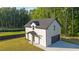 Side exterior showing garage, with a well-kept lawn, black trim, and white brick at 2631 Sardis Way, Buford, GA 30519