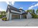 Spacious three-car garage with modern doors and ample parking space, with a charming bench nearby at 2631 Sardis Way, Buford, GA 30519
