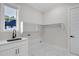 Bright laundry room with custom cabinets, a sink, and marble tile flooring at 2631 Sardis Way, Buford, GA 30519