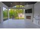 Spacious covered patio features a grill, fireplace, television, and views of the backyard at 2631 Sardis Way, Buford, GA 30519