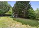 This backyard includes a play structure and chain-link fence providing a safe and fun space for children to play at 735 Poplar Rd, Dallas, GA 30157