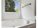 Large white tub with chrome fixtures next to a window at 735 Poplar Rd, Dallas, GA 30157