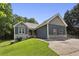Charming home boasts a well-manicured lawn, blue siding, stone accents, and a long driveway leading to the residence at 735 Poplar Rd, Dallas, GA 30157