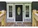 Front door and entry features wood railings, gray stone, and a black door with an oval window at 735 Poplar Rd, Dallas, GA 30157