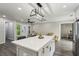 Kitchen with island, stainless steel appliances, modern lighting, and open to living and dining areas at 735 Poplar Rd, Dallas, GA 30157