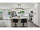 Bright kitchen with white cabinets, stainless appliances, kitchen island with stools, and contemporary light fixture at 735 Poplar Rd, Dallas, GA 30157