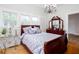 Bright bedroom features a wooden sleigh bed, beautiful chandelier, and hardwood floors at 791 E Main Street, Canton, GA 30114