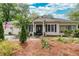 Charming single-story home with a welcoming front porch, lush landscaping, and an American flag at 791 E Main Street, Canton, GA 30114