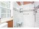 Updated tiled shower with glass door, bench, and window for natural light at 791 E Main Street, Canton, GA 30114