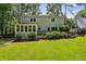 View of home's exterior with a lush backyard, sunroom and deck at 119 Laurel Mill Ct, Roswell, GA 30076