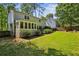 Backyard showcasing a home's exterior with a sunroom and well-manicured lawn at 119 Laurel Mill Ct, Roswell, GA 30076