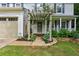 Close-up of a charming home entrance featuring a pergola, well-kept lawn, and an attached two-car garage at 119 Laurel Mill Ct, Roswell, GA 30076