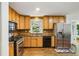 Well-lit kitchen with stainless steel appliances, light wood cabinets, and a view of the backyard at 119 Laurel Mill Ct, Roswell, GA 30076