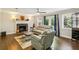 Comfortable living room with hardwood floors, ceiling fan, fireplace, and neutral colored furniture at 119 Laurel Mill Ct, Roswell, GA 30076