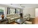 Cozy living room featuring a ceiling fan, hardwood floors, and neutral colored furniture at 119 Laurel Mill Ct, Roswell, GA 30076