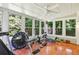 Sunroom with multiple windows and a ceiling fan showcases exercise equipment at 119 Laurel Mill Ct, Roswell, GA 30076