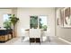 Well-lit dining area with a wooden table, white chairs, and contemporary decor at 2483 Cotton Ln, Douglasville, GA 30135