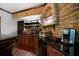 Basement bar area with wooden cabinetry, bar stools, and a mounted TV at 685 Sienna Dr, Cumming, GA 30040