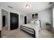Neutral bedroom with black door, metal bedframe, floral art, and side table at 685 Sienna Dr, Cumming, GA 30040
