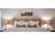 Close-up of main bedroom bed with neutral colors and rustic nightstand lamps at 685 Sienna Dr, Cumming, GA 30040
