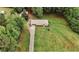 Aerial view of a single-story home with an expansive lawn, mature trees, and a long driveway at 8394 Banks Mill Rd, Douglasville, GA 30135