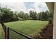 Expansive backyard features a large lawn, bordered by trees, and secured with a chain-link fence at 8394 Banks Mill Rd, Douglasville, GA 30135