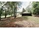 Large backyard featuring an outbuilding, lots of trees, and a home's exterior at 8394 Banks Mill Rd, Douglasville, GA 30135
