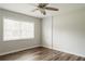 Neutral bedroom featuring ceiling fan, laminate flooring, and a bright window at 8394 Banks Mill Rd, Douglasville, GA 30135