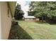 Exterior side view of home revealing siding, A/C unit, and large detached garage with white doors at 8394 Banks Mill Rd, Douglasville, GA 30135