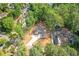 Aerial view of new construction home on wooded lake lot with newly paved driveway and partially cleared yard at 912 Oak Dr, Woodstock, GA 30189