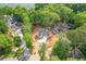 Aerial view of new construction home with water views and a newly paved driveway in a wooded lot at 912 Oak Dr, Woodstock, GA 30189