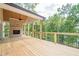 View of back porch and outdoor brick fireplace overlooking backyard, wooded area, and the lake at 912 Oak Dr, Woodstock, GA 30189