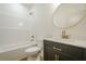 Bathroom with bathtub, black vanity with gold hardware, toilet, and round mirror at 912 Oak Dr, Woodstock, GA 30189