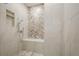 A tiled shower stall with a built-in bench and shelving, features a rainfall shower head at 912 Oak Dr, Woodstock, GA 30189